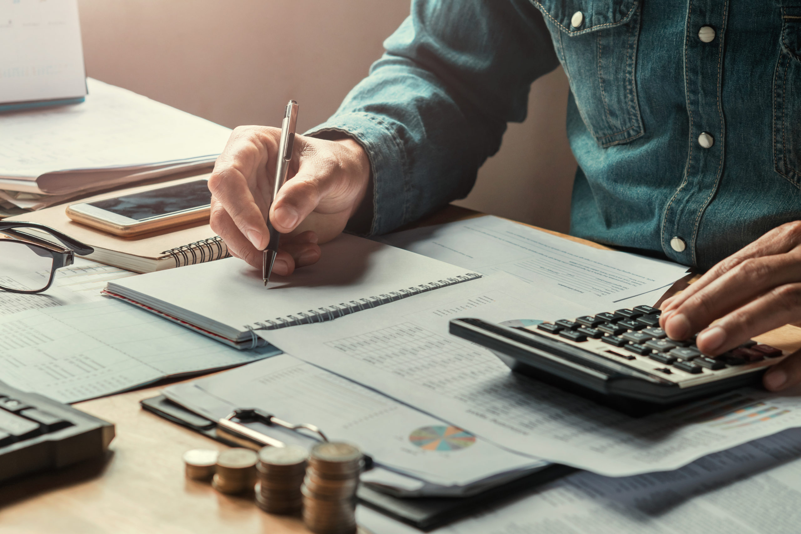 Business Man Using Calculator To Calculate With Writing Of Data - Contabilidade em Santa Catarina | Amaral Contabilidade