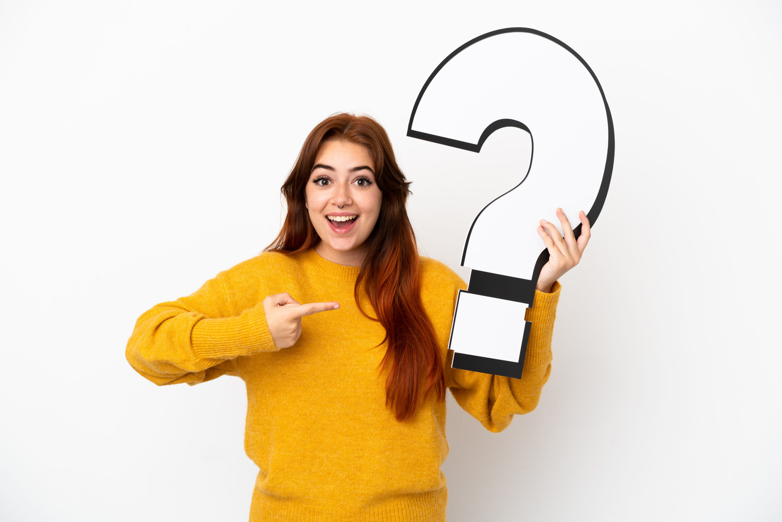 Young Redhead Woman Isolated On White Background Holding A Question Mark Icon With Surprised Expression - Contabilidade em Santa Catarina | Amaral Contabilidade